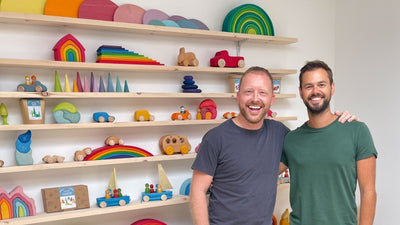 Simon with Marco from Grimm's Wooden Toys in front of a wall of colourful wooden Grimm's children's toys and shelves.