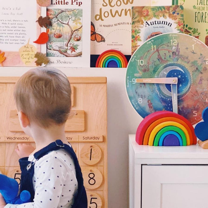 Child updating perpetual calendar as part of morning circle time - Oskar's Wooden Ark
