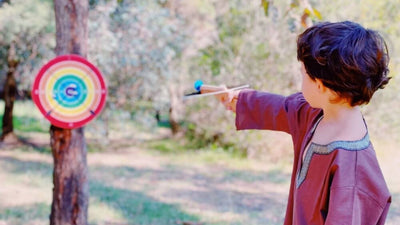 Child playing with VAH handmade wooden crossbow for imaginative role play