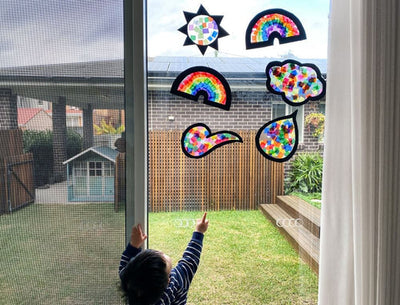 Child admiring handmade paper sun catchers using transparent waxed kite paper at Oskar's Wooden Ark in Australia