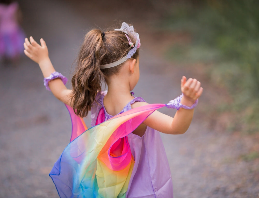 Child dancing while wearing Sarah's Silks Playsilks and accessories