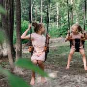 Two children playing on Solvej Scandi wooden swings outdoors