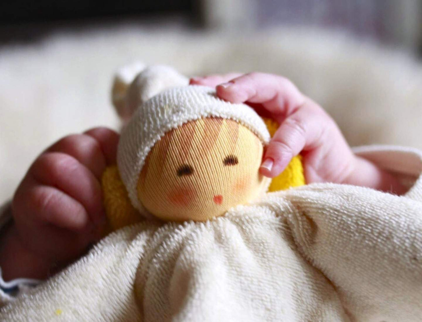 Baby holding a Nanchen Natur comfort toy