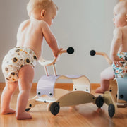 Toddlers riding Wishbone Mini Flip Wooden Ride On Toys from Oskar's Wooden Ark in Australia