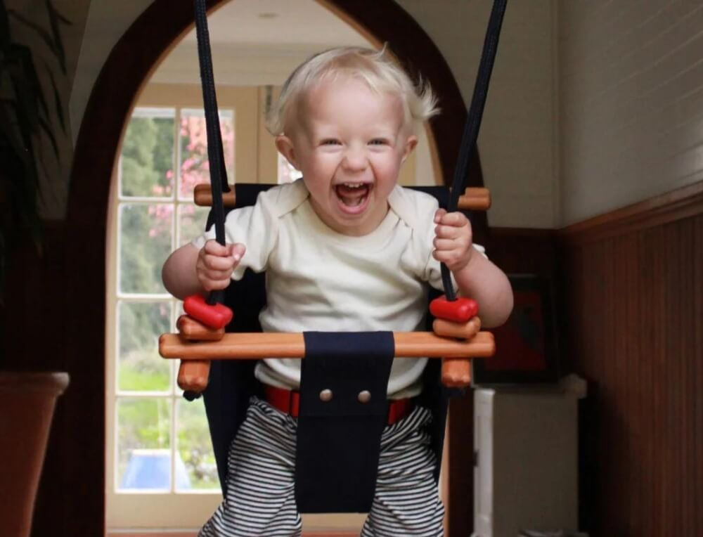 Toddler smiling and swinging on SOLVEJ Swing from Australia