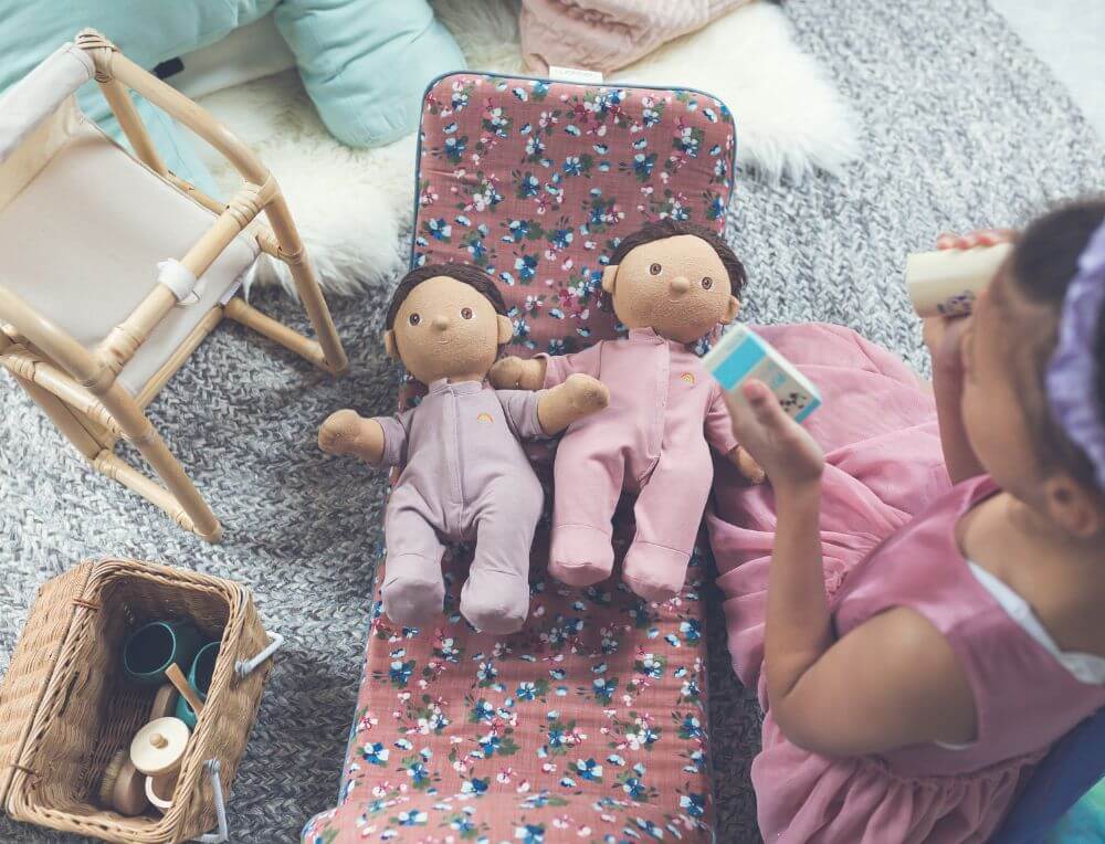 Girl absorbed in imaginative open ended role play with Olli Ella Dinkum Dolls and accessories from Oskar's Wooden Ark in Australia