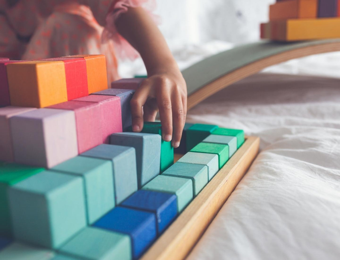 Child playing with Grimm's Large Stepped Pyramid wooden building blocks