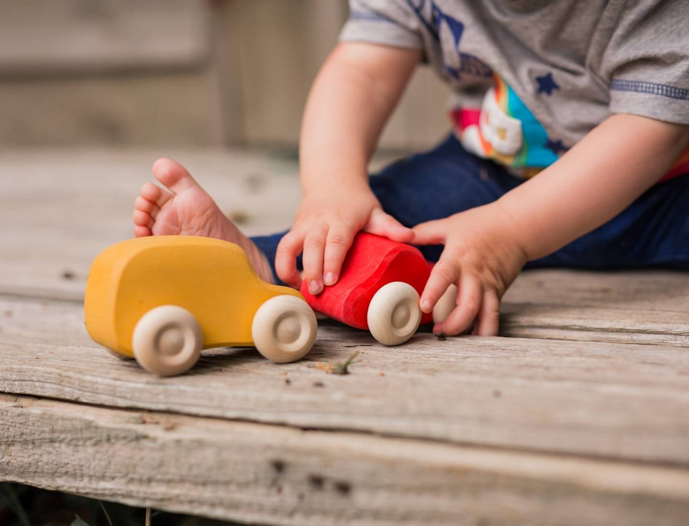 Toddler playing with Grimm's wooden toy cars