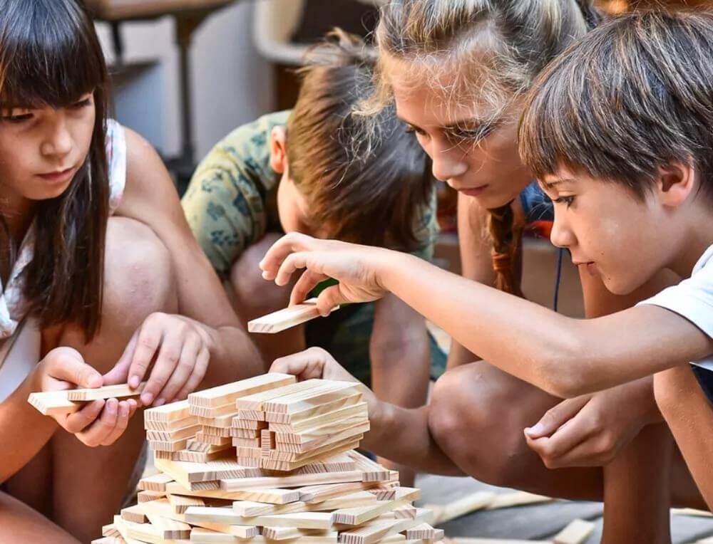 Children working together on a collaborative classroom building project using KAPLA wooden building planks at Oskar's Wooden Ark in Australia