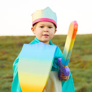 Boy engaging in imaginative role play, dressed up in a Sarah's Silks cape and crown with toy sword and shield from Oskar's Wooden Ark in Australia