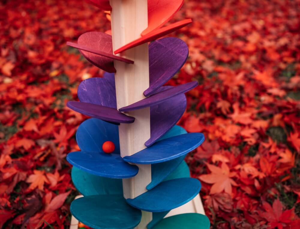 Marble sound tree in an outdoor setting with autumn leaves - wooden toys on sale at Oskar's Wooden Ark