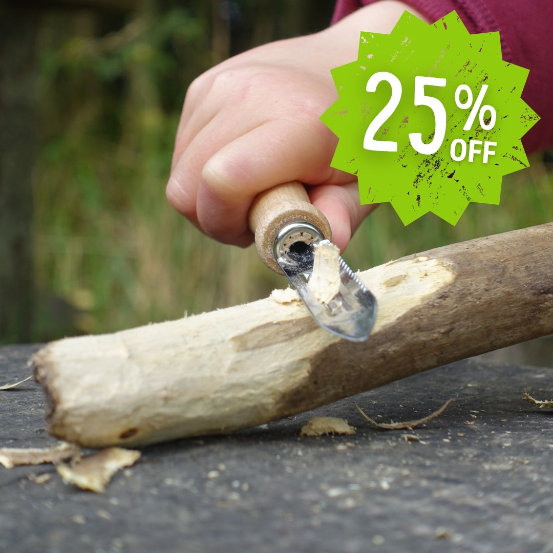 Child's hand using a Kids at Work whittling knife with a 25% off discount label in the corner.