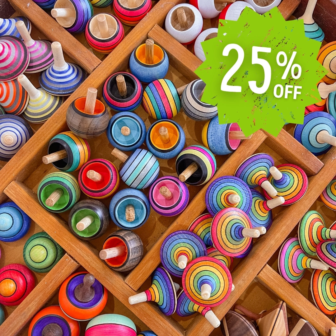 Colourful Mader wooden spinning tops on a wooden grid with a 25% off label.