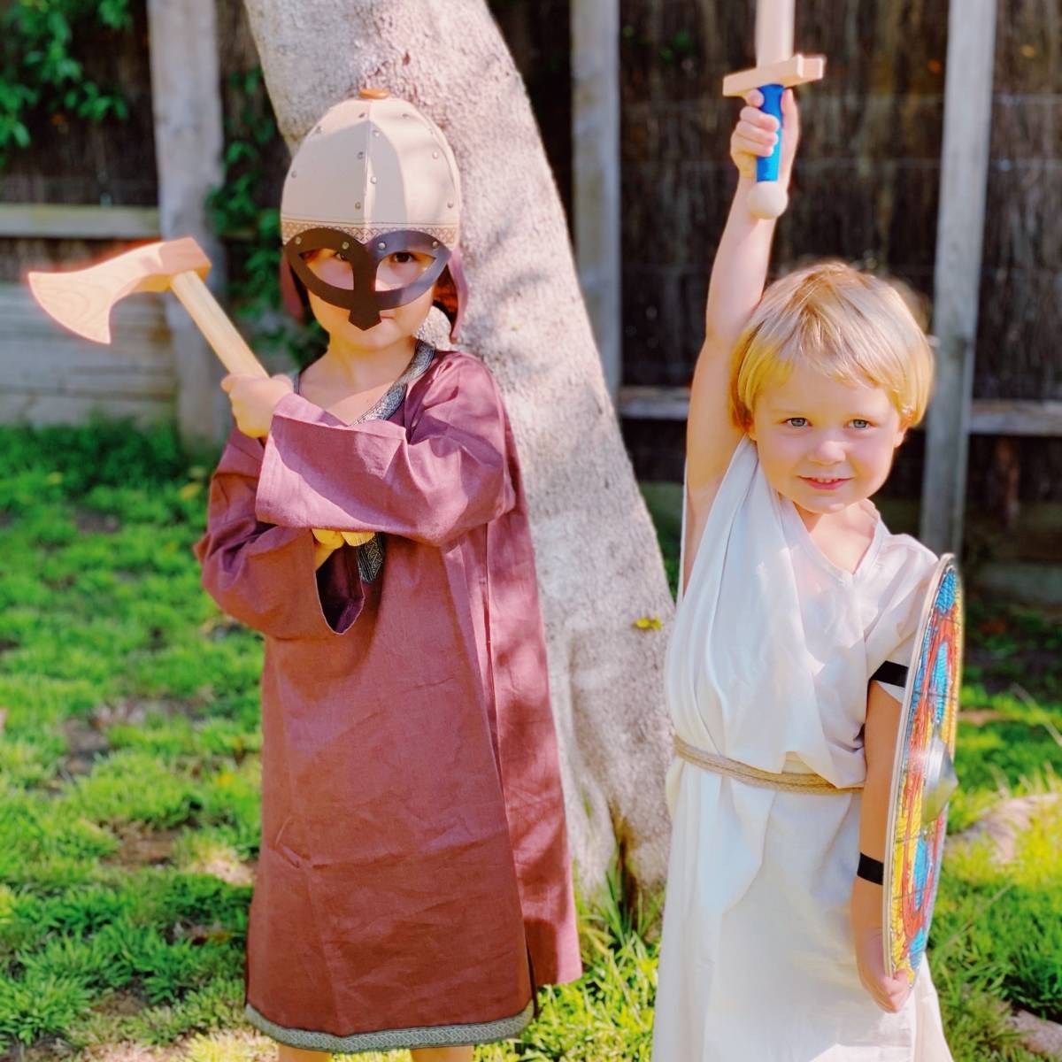 Children in medieval costumes exploring risky play with wooden swords