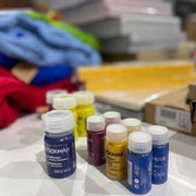 Range of Stockmar Aquarelle paints on packing table with skeins of eco-wool and school products from Oskar's Wooden Ark  in Australia