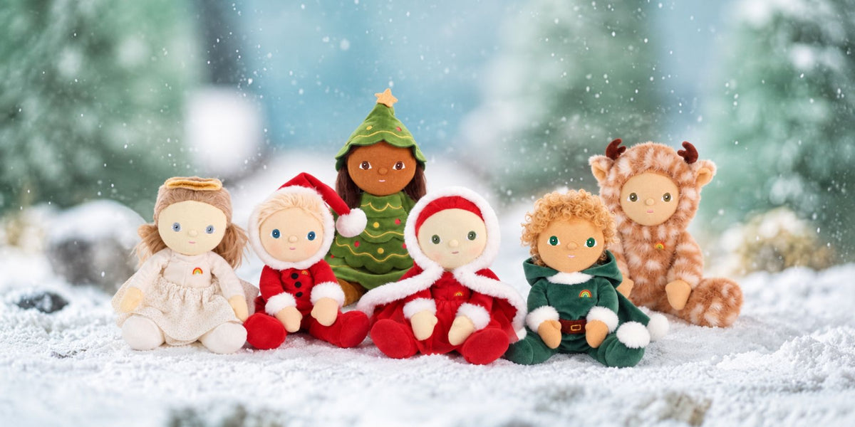 Six limited edition Christmas Dinkum dolls sitting against a snowy backdrop