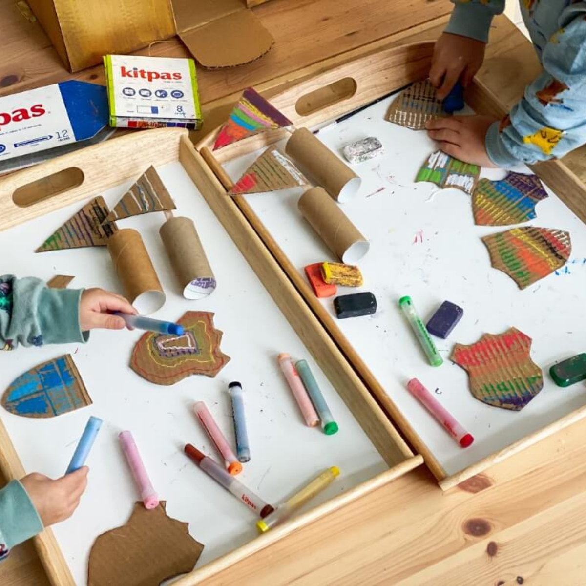 Children colouring cardboard boxes to build a castle craft