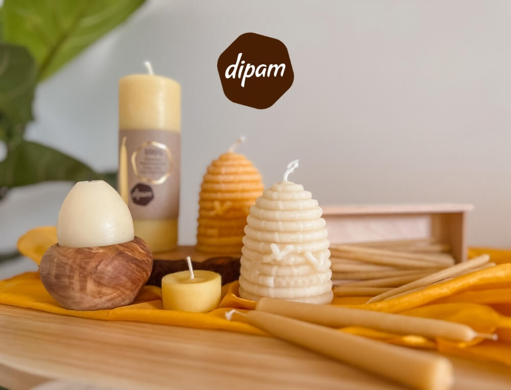 Dipam candles lifestyle image with logo, featuring a display of beeswax candles on a wooden surface – Oskar's Wooden Ark