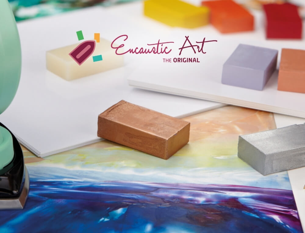 Encaustic wax art lifestyle image with logo, featuring coloured wax blocks and an abstract painting – Oskar's Wooden Ark