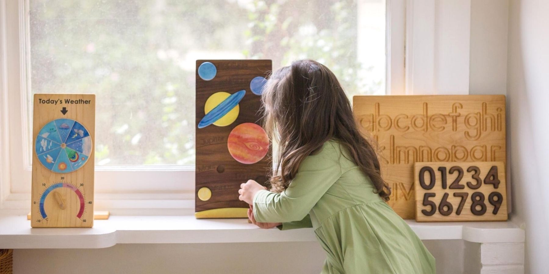 Child playing with wooden educational toys by a window