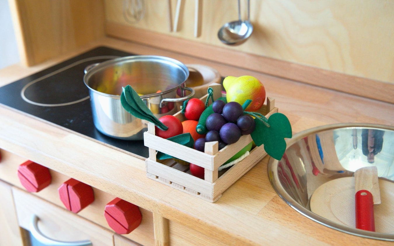 Gluckskafer toy kitchen set with Erzi wooden play fruits and vegetables on a wooden countertop