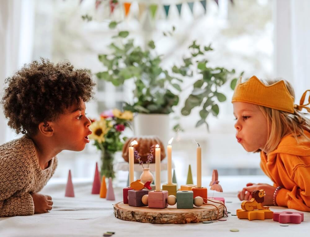 Children blowing out candles - Waldorf Birthday celebration with celebration ring, candles and decorative items from Grimm's Wooden Toys, Available in Australia from Oskar's Wooden Ark