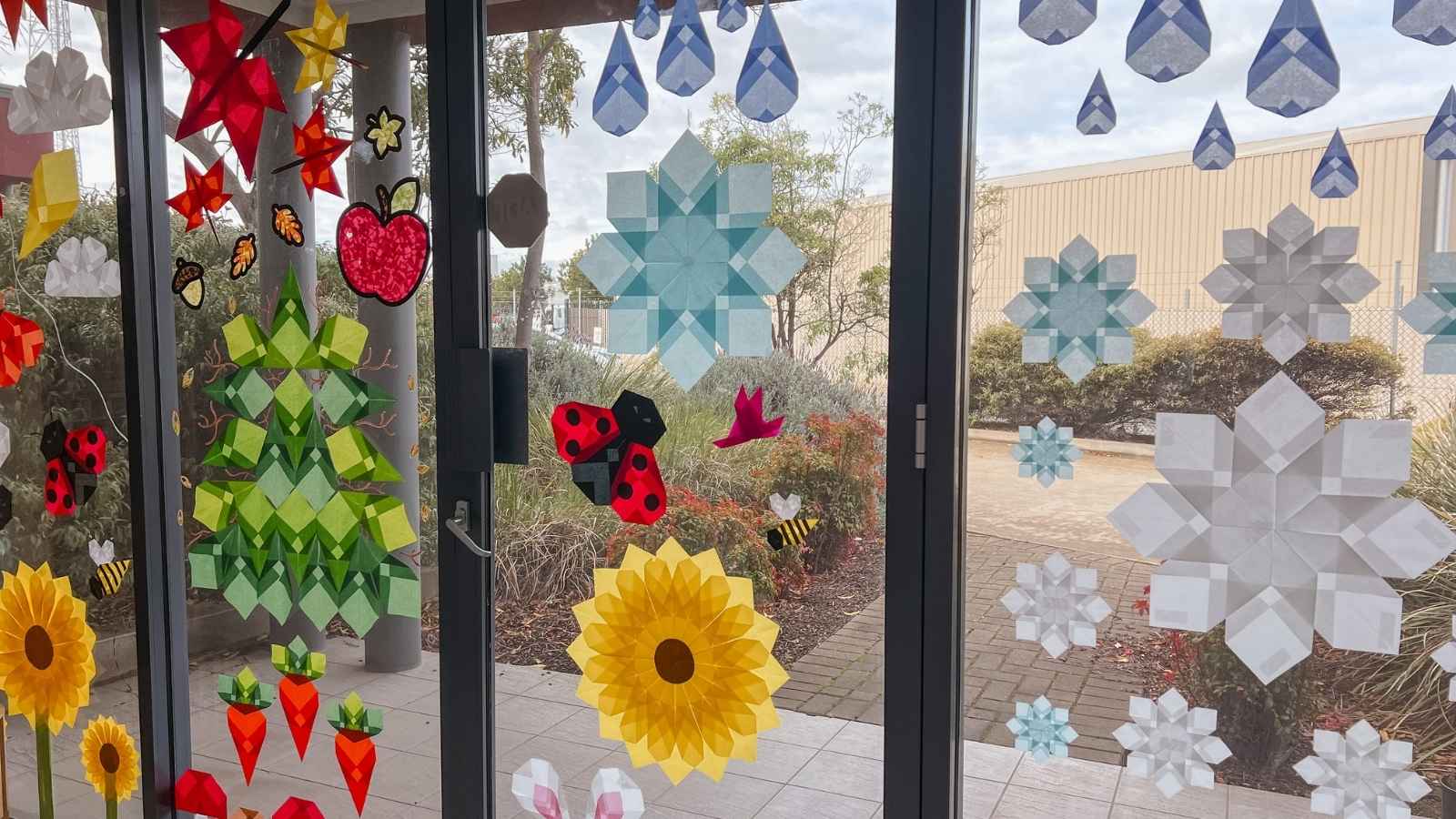 Paper window art display on a window, with sunlight shining through.