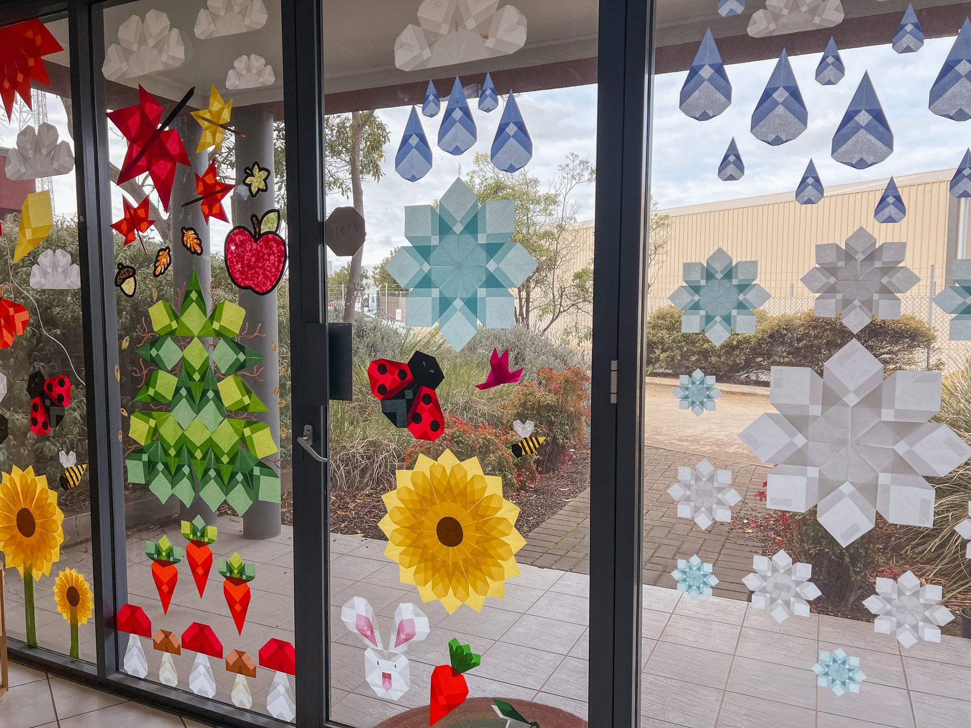 Paper window art display on a window, with sunlight shining through.