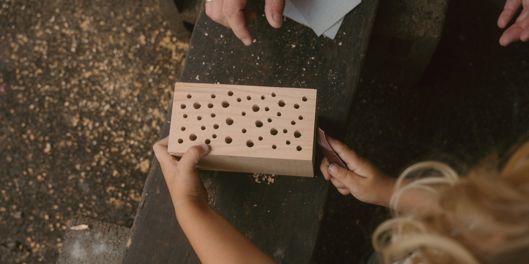 Close-up of little hands creating a Kids at Work DIY kit on a textured surface