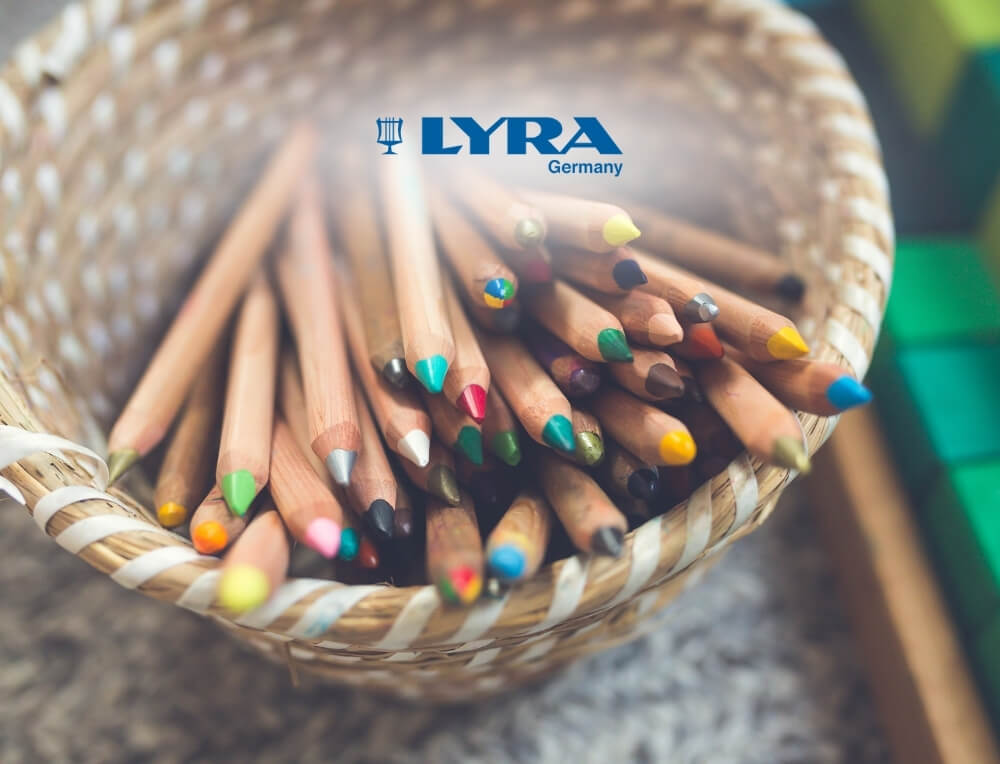 LYRA Art lifestyle image with logo, featuring a close-up of a woven basket filled with LYRA wooden coloured pencils of various colours – Oskar's Wooden Ark
