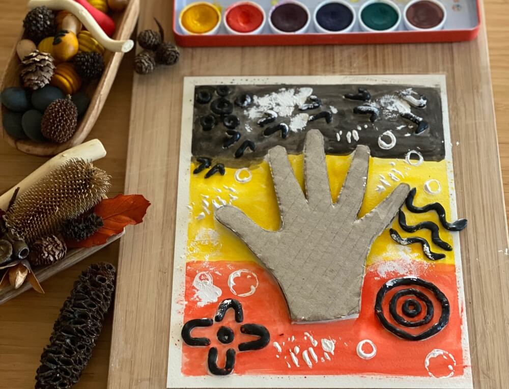 Completed First Nations nature-inspired artwork with hand stencil and painted symbols