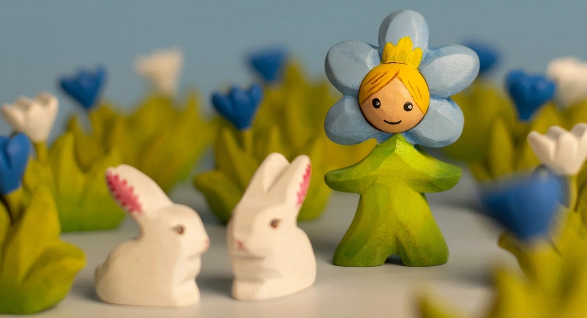 Bumbu wooden toy figure of a flower fairy with two bunnies and flowers in the background