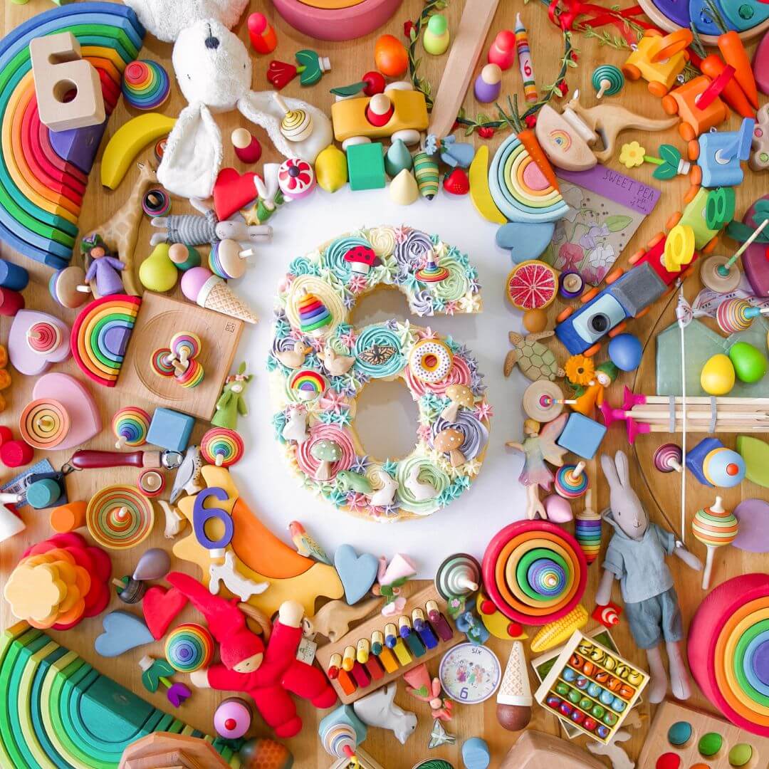 Birthday Cake surrounded by an assortment of colourful wooden toys, offered at 20% off in Oskar's Wooden Ark 6th Birthday Sale