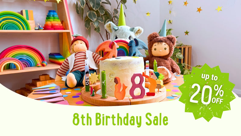Children's birthday party setup with toys, a cake, and a '20% off' sale sign for Oskar's Wooden Ark's 8th birthday