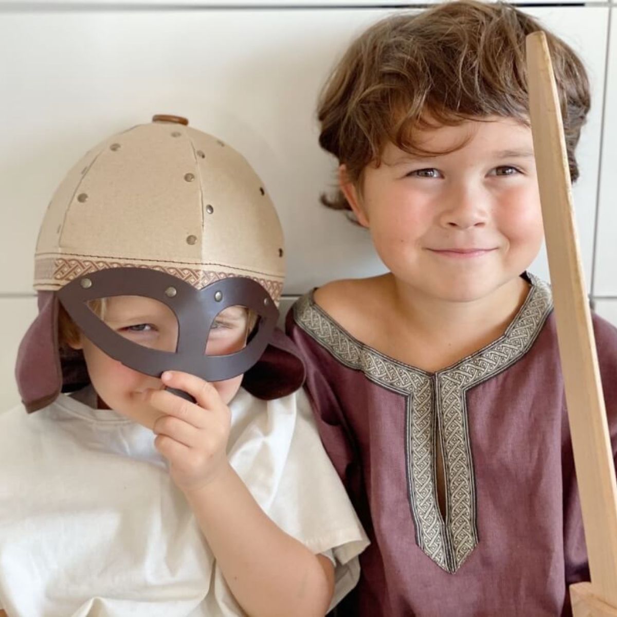 Children in medieval costumes exploring risky play with wooden swords