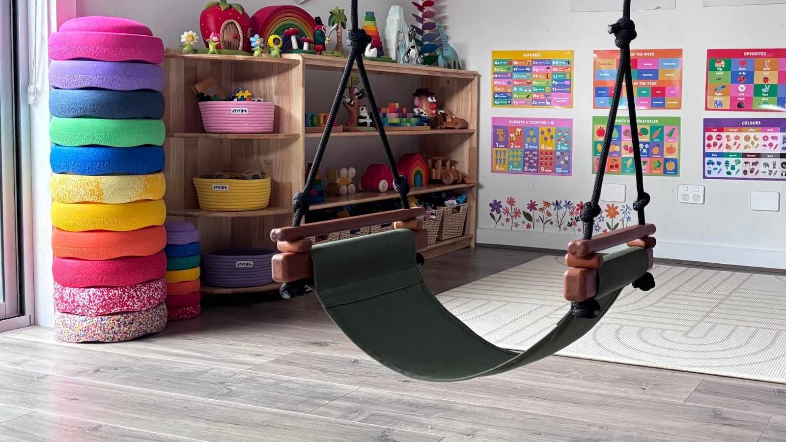 A Solvej Swing hanging in a playroom surrounded by familiar OWA toys.