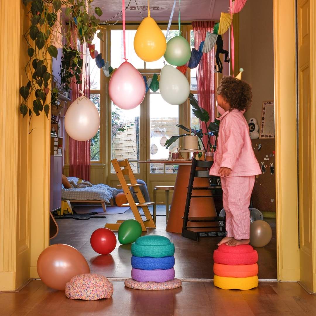 Child celebrating a Birthday in a home setting with Stapelstein stepping stones and balloons