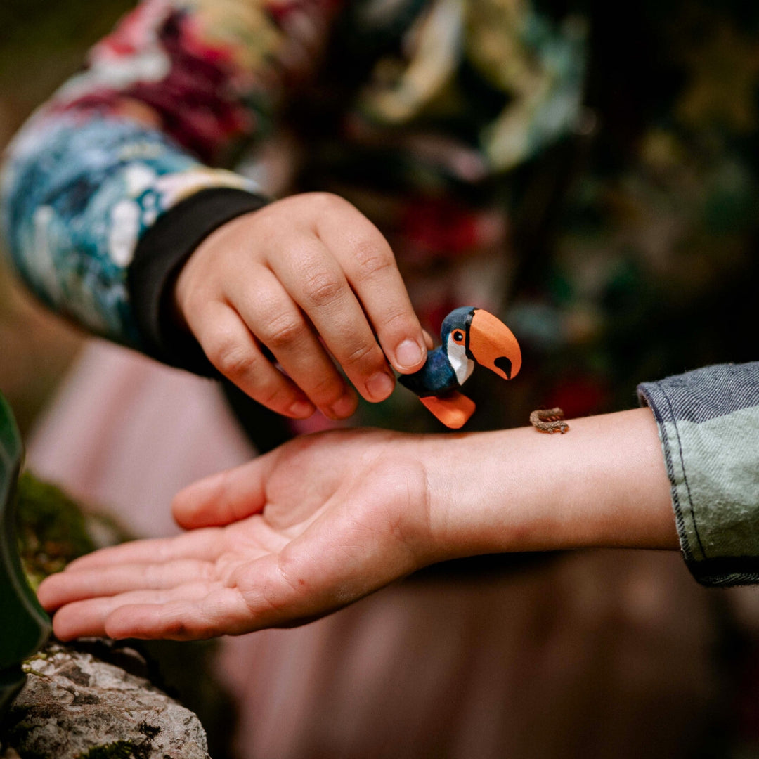 BumbuToys Handcrafted Wooden Bird Toucan Standing from Australia being held by a child's hand