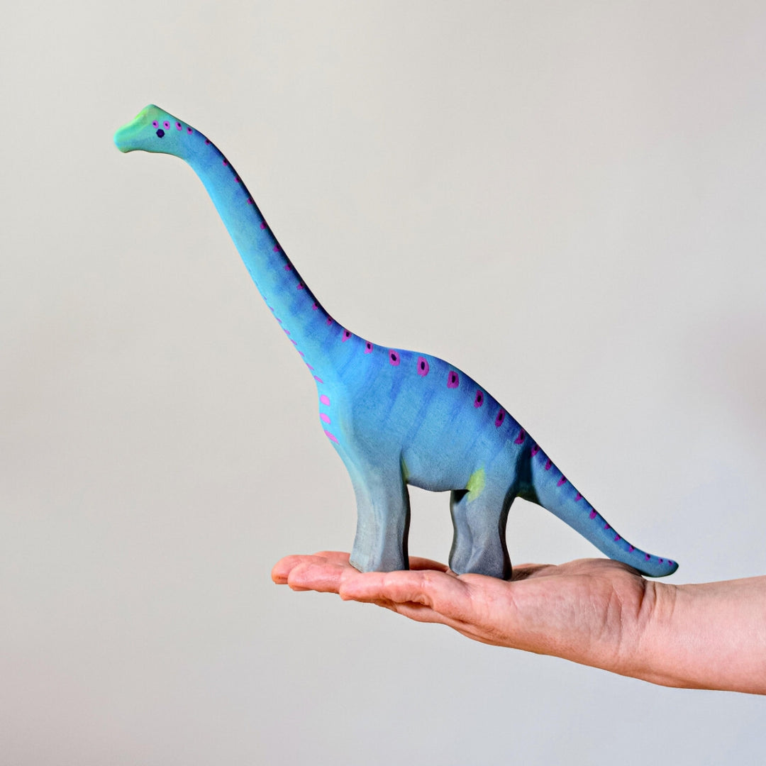 BumbuToys Handcrafted Wooden Dinosaur Brontosaurus Big from Australia on an adult person's palm