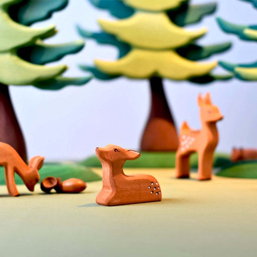 BumbuToys Handcrafted Wooden Farm Animal Deer Fawn Resting from Australia in a small-world play setting