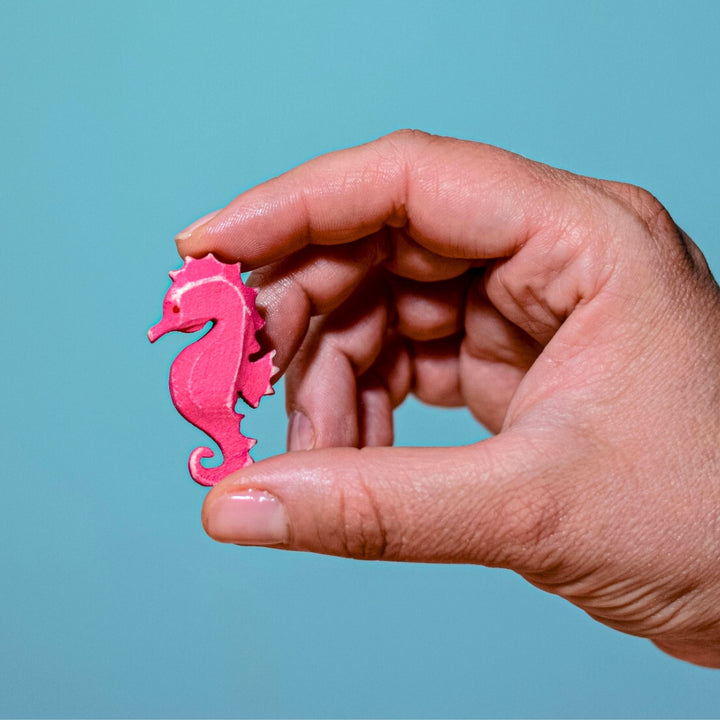 BumbuToys Handcrafted Wooden Seahorse from Australia held by an adult person's hand