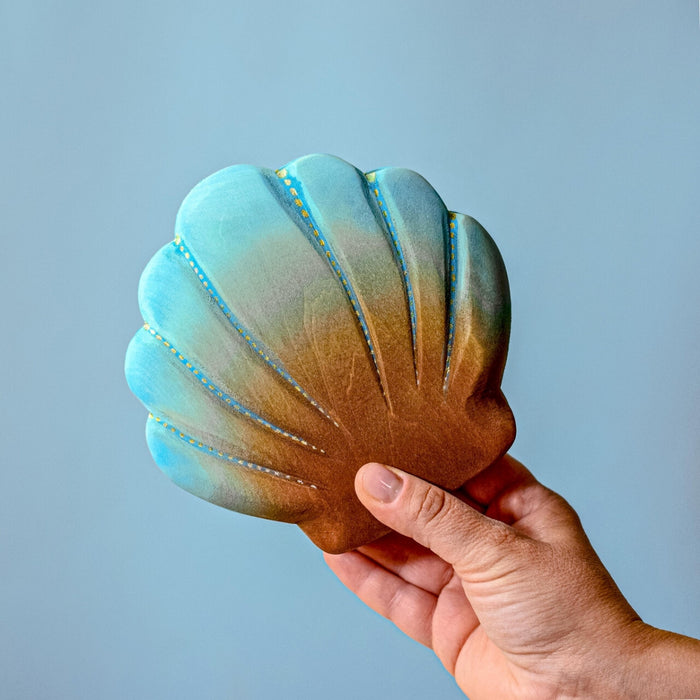 BumbuToys Handcrafted Closed Large Shell Wooden Toy from Australia on an adult person's hand