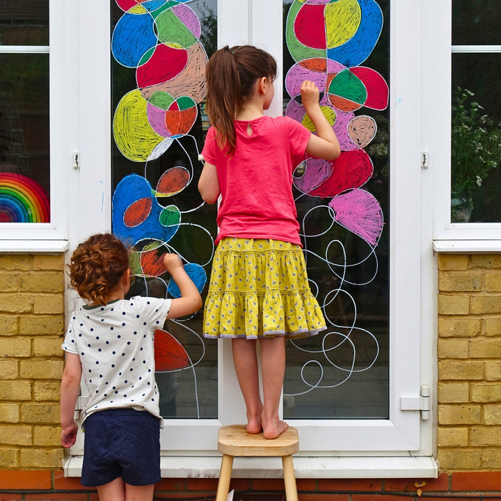 Children drawing on a window using Kitpas removeable rice bran wax crayons from Australia