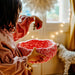 Child holding a red and white patterned stepping stone with a blurred indoor background