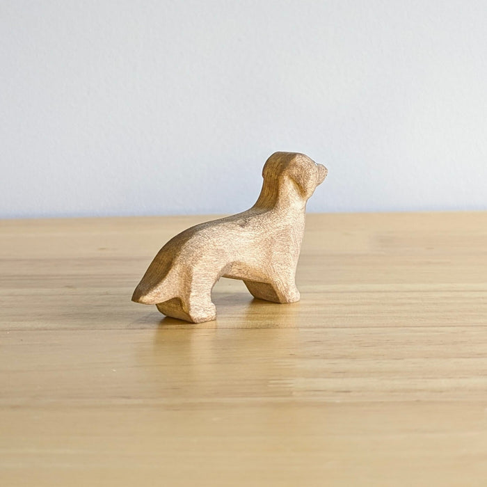 A NOM Handcrafted Wooden miniature Dachshund Sausage Dog model sitting on a table top