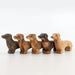 A pack of 5 NOM Handcrafted Wooden miniature Dachshund Sausage Dog models, all with different coloured markings, looking in one direction
