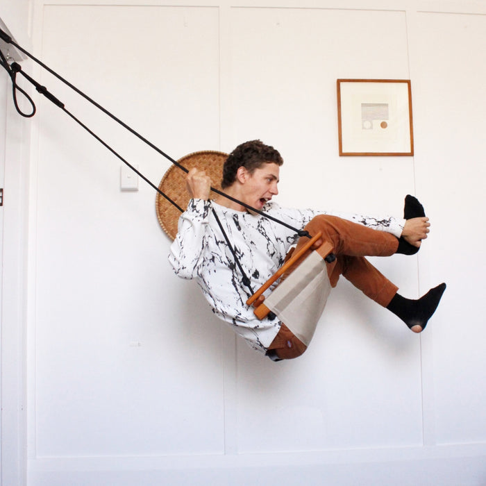 A man doing a play swing trick indoors using a SOLVEJ Adult & Child Swing Soft Linen Colour from Australia