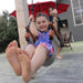 A smiling young girl swinging outdoors in her yard using SOLVEJ Adult & Child Swing Slate Grey Colour from Australia