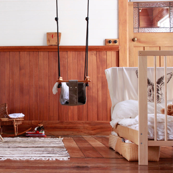 Classic Taupe SOLVEJ Convertible Baby & Toddler Swing hung indoors in a child's bedroom