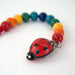 NI-520080 Gluckskafer Wooden dummy chain w ladybird clip - Rainbow